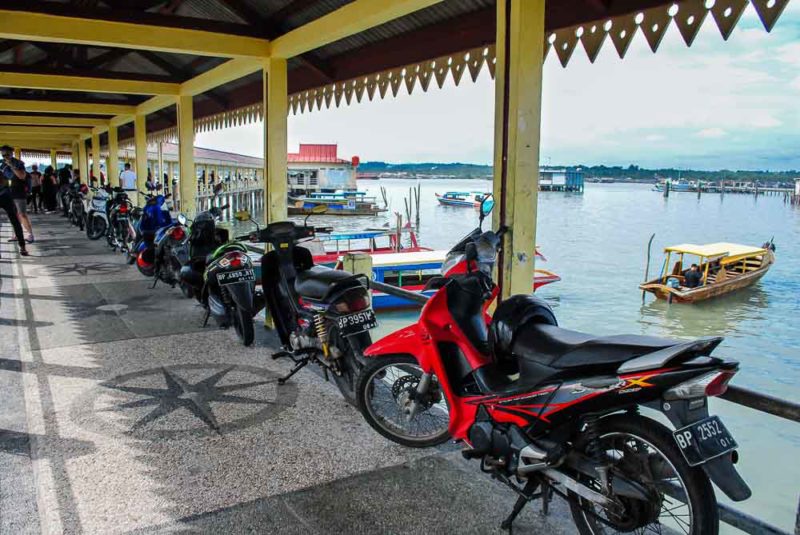 Scooters parked on the pier near Senggarang Village