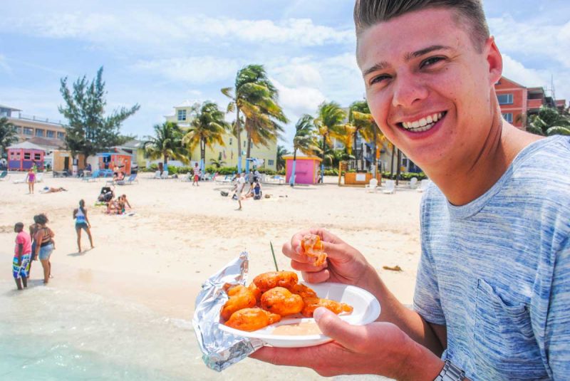 Eating Conch fritter on Junkanoo beach Nassau Bahamas