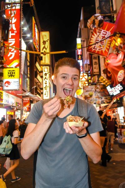 Eating octopus balls (yakitora) on Dotonbori Street Osaka