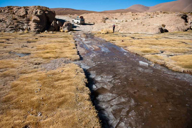 Our four-wheel drive breaks through surface ice as we cross a shallow stream in the morning