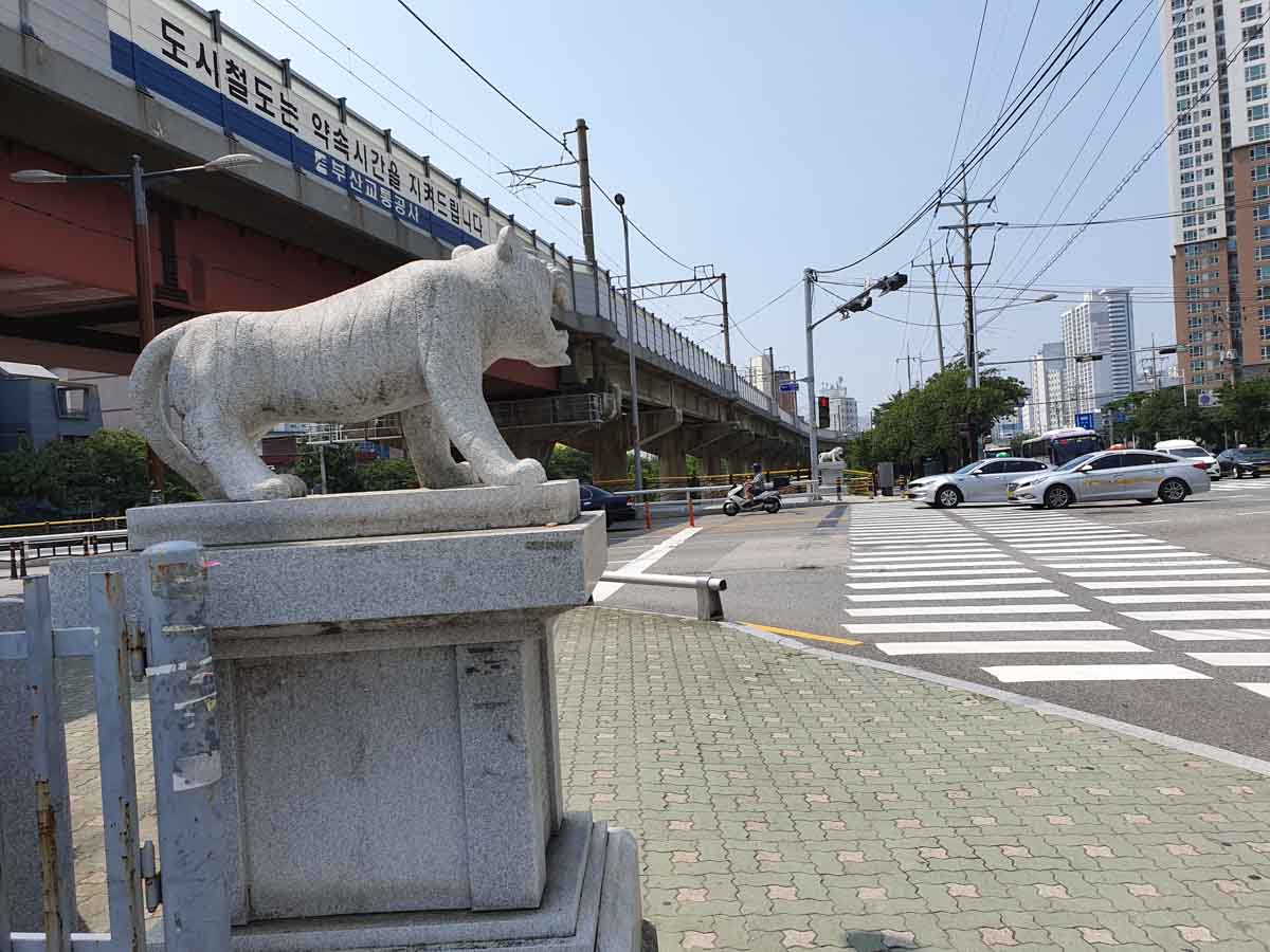 Cross the road to the right at the tiger statue